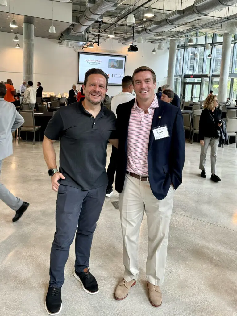 Two men smiling at a University of Miami startup accelerator networking event.