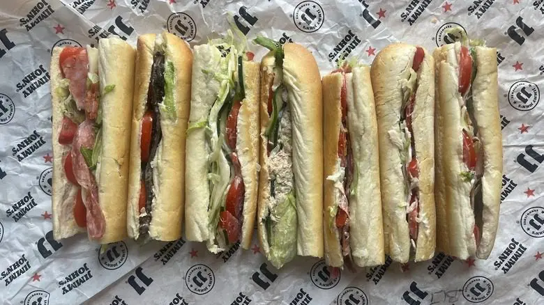 Overstuffed cheesesteak hoagie with lettuce and tomato served with fries on a diner plate.