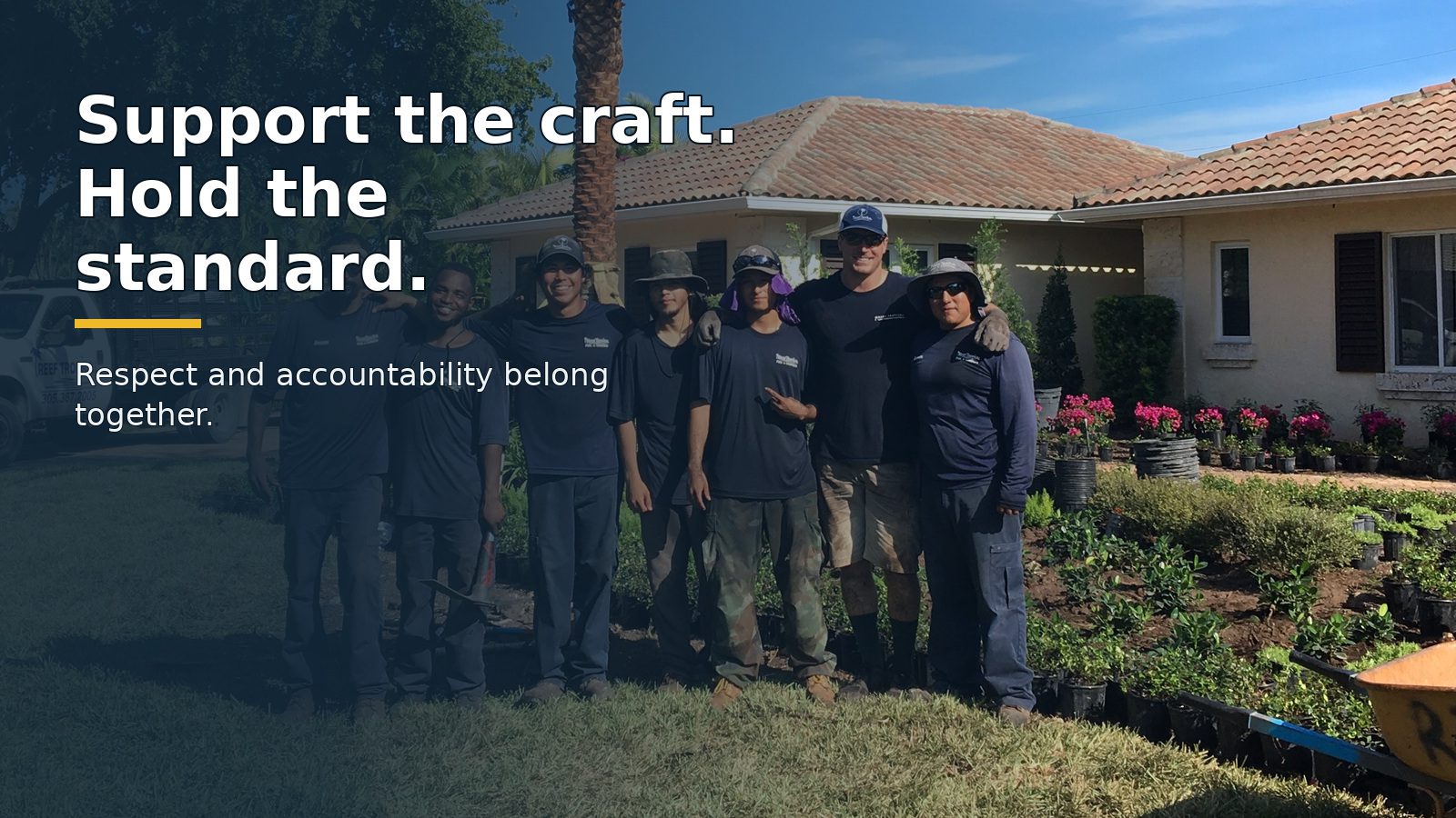 A South Florida landscape crew stands together at a completed field site.
